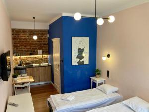ワルシャワにあるHoza 35 A-E by Homeprimeの青い壁の客室で、ベッド2台が備わります。