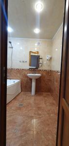 a bathroom with a sink and a toilet and a tub at Odzun Hotel in Alaverdi