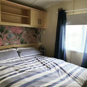 a bed in a room with a window and a bed sidx sidx at Trimingham Static Van in Trimingham