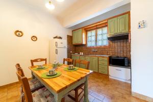 a kitchen with a wooden table and chairs in a room at Villa Prima in Kato Korakiana
