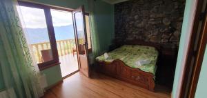 a small bedroom with a bed and a balcony at Odzun Hotel in Alaverdi