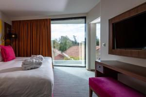 a hotel room with a bed and a flat screen tv at Crowne Plaza Montpellier Corum, an IHG Hotel in Montpellier