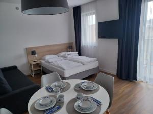 uma sala de estar com uma cama, uma mesa e cadeiras em WILLA KORSARSKA em Władysławowo