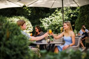 a group of people sitting at a table with drinks at Hotel Wettstein in Basel