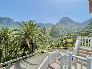 a balcony with palm trees and a view of mountains at Ca Yaya - Big House with Terraces - Rooftop & Views in Hermigua