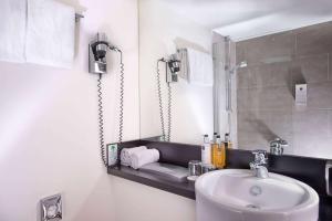 a bathroom with a sink and a mirror at Wyndham Stuttgart Airport Messe in Stuttgart