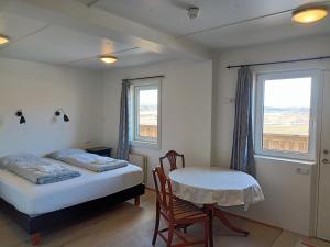 a bedroom with a bed and a table and a window at Guesthouse Storu-Laugar in Laugar