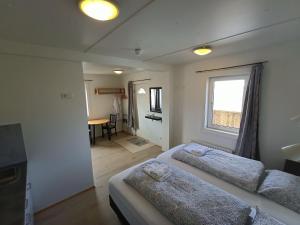 ラウガーにあるGuesthouse Storu-Laugarのベッドルーム1室(ベッド2台、窓、テーブル付)