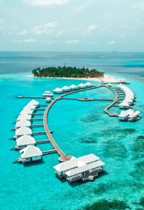 an island with many white resorts in the water at Diamonds Athuruga Maldives Resort & Spa in Athuruga Island