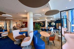 un restaurant avec des tables et des chaises bleues et blanches dans l'établissement Mercure Dunkerque Centre Gare, à Dunkerque