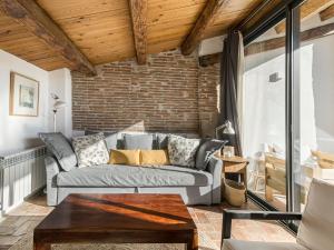 a living room with a couch and a brick wall at Cal Rellotger de Solsona in Solsona