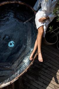 a woman sitting on top of a wooden bench at Femmasteren Hotel & Hostel in Marstal