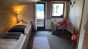 a room with two beds and a table and a chair at Quartier Severin in Berwang