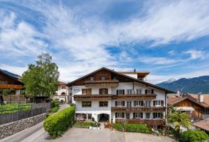 a building in a village with mountains in the background at Residence Alpina Comfort Nr 1 in Tesimo