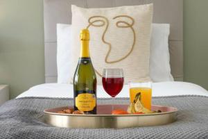 a tray with a bottle of wine and a plate of food at Blandford House with Free Parking, Fast Wifi, Smart TV with Netflix and Private Garden by Yoko Property in Coventry
