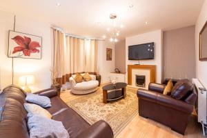 a living room with a leather couch and a fireplace at Captivating 5-Bed House in Liverpool with parking in Liverpool