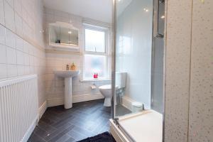 a bathroom with a toilet and a sink and a shower at Captivating 5-Bed House in Liverpool with parking in Liverpool