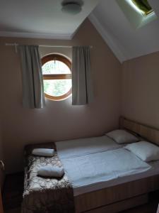 um quarto com uma cama grande e uma janela em Tiborc Apartman em Gyula