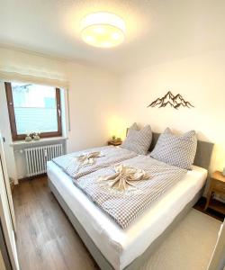 a bedroom with a large bed with a bow on it at Balkon mit ruhigem Garten in Sonthofen in Sonthofen