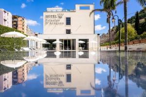 un edificio con reflejo en una piscina de agua en Hotel Principe d'Aragona, en Módica