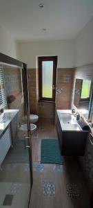 a bathroom with a sink and a shower and a toilet at La Terrazza sul Borgo in Mombaldone