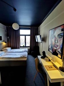 フディクスバルにあるHotell Temperanceのベッドとデスクが備わるホテルルームです。