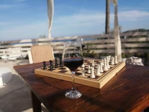 a glass of wine sitting on a chess board at Filia Bungalow in Archangelos