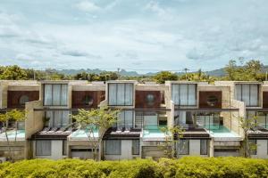 an apartment building with windows on the side of it at Fallingwater Pool Villa by Cross River Kwai in Kanchanaburi City