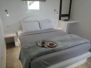 a bed with a plate of food on top of it at Filia Bungalow in Archangelos