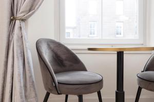 een tafel en twee stoelen naast een raam bij JOIVY Attractive flat near Haymarket Station in Edinburgh