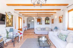 a living room with white furniture and wooden ceilings at Holiday Villa Near Denia in Adsubia