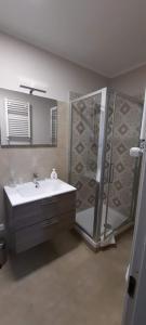 y baño con lavabo y ducha. en Cà Trifolera Barbaresco - Appartamento per 2 o 4 persone immerso nei vigneti - Free Parking Wi-Fi -, en Barbaresco