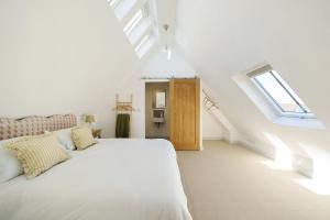 um quarto branco com uma cama e uma janela em Hollybank Barn em Dorchester