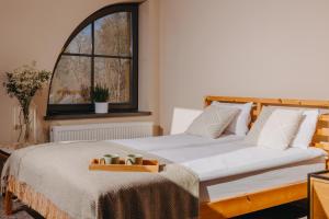 Un dormitorio con una cama y una bandeja. en Pokoje Bukowiec Folwark i Park en Bukowiec