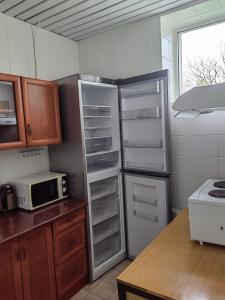 uma cozinha com um frigorífico e um micro-ondas em Suure-Jaani Veekeskuse Sürgavere majutus em Sürgavere