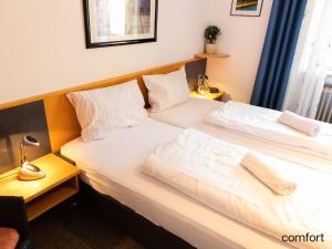 2 camas individuales en una habitación de hotel en Ferienpark Geyersberg en Freyung