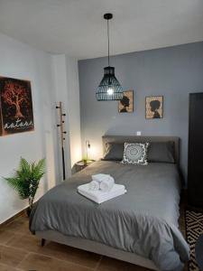 ein Schlafzimmer mit einem Bett mit zwei Handtüchern darauf in der Unterkunft Petite suite with backyard. in Mytilini