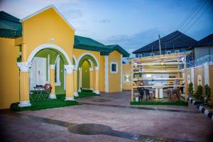 uma casa amarela com uma mesa num pátio em Stylish 1-Bed-Apt With 24hrs Power + Fast Wi-Fi em Lagos