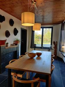 a dining room with a wooden table and chairs at Guesthouse Le petit chapeau in Durbuy