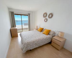 ein Schlafzimmer mit Bett und Blick auf das Meer in der Unterkunft Turquesa & Ambar Apartments Formentera in La Savina