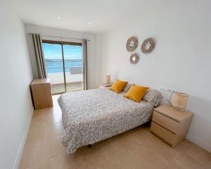 a bedroom with a bed and a view of the ocean at Turquesa & Ambar Apartments Formentera in La Savina