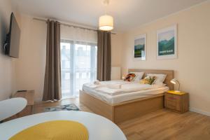 a bedroom with a bed and a large window at RentPlanet - Green Park Resort in Szklarska Poręba
