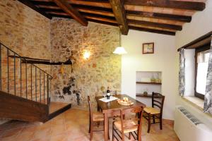 uma sala de jantar com mesa e cadeiras e uma parede de tijolos em Girasole - Agriturismo Fogliani em Giano dellʼUmbria