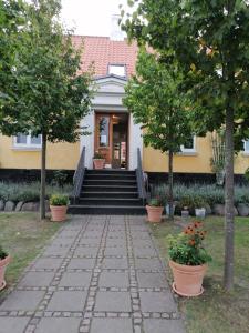 a house with stairs leading to the front door at Femmasteren Hotel & Hostel in Marstal