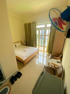 een slaapkamer met een bed en een stoel in een kamer bij Khách sạn Anh Thư in Ho Chi Minh-stad