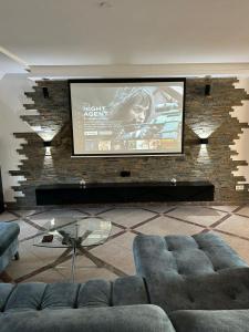 a living room with a couch and a large screen at Luxuriöse Wohnung im Herzen von RLP in Bobenheim-Roxheim