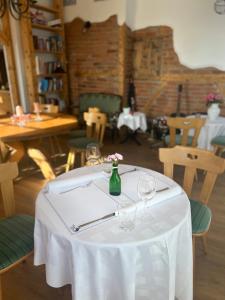 a white table with glasses and a vase on it at Boutique Hotel and Apartments Pension Sternen in Todtmoos