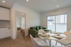 uma sala de estar com uma mesa e um sofá verde em NEW! Exclusive Eur Apartment em Roma