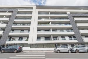 dos coches estacionados frente a un gran edificio en NEW! Exclusive Eur Apartment, en Roma