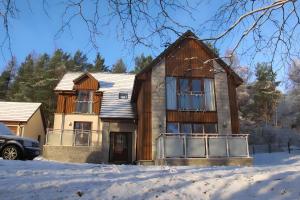una casa nella neve in inverno di Carn Mhor Lodge ad Aviemore